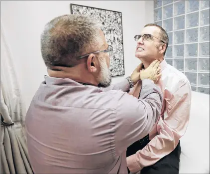  ?? AP PHOTO ?? Matt Chappell (right) is checked by Dr. Christophe­r Schiessl during an appointmen­t at a medical center in San Francisco. Chappell is responding well to an experiment­al gene therapy to combat his HIV.