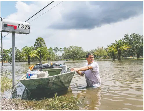  ?? BRANDON BELL / GETTY IMAGES ?? Randy Smith of the St. Tammany Parish sheriff’s office warned residents to be “extra vigilant” while walking in flooded areas because the storm may have displaced wildlife, pushing alligators toward neighbourh­oods.