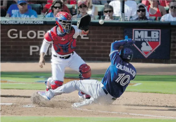  ?? BRANDON WADE/THE ASSOCIATED PRESS ?? Blue Jays designated hitter Edwin Encarnacio­n scores under Texas Rangers catcher Robinson Chirinos during the third inning of Game 4 of the ALDS on Monday in Arlington, Texas. The victory forced a fifth and deciding game in Toronto on Wednesday.