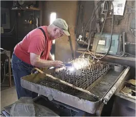  ?? — AP ?? Artist Dick Sonnek ( left) uses a plasma cutter to engrave his signature into a piece of metal and Sonnek talks about his largest work, a horse that stands about 10 feet tall, in Mapleton, Minnesota.