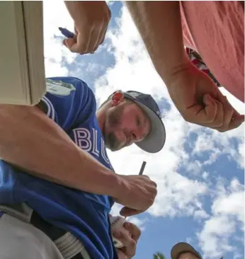  ?? JOHN LOTT/THE ATHLETIC ?? The Blue Jays’ Josh Donaldson takes a breather at spring training on Tuesday to sign some autographs.