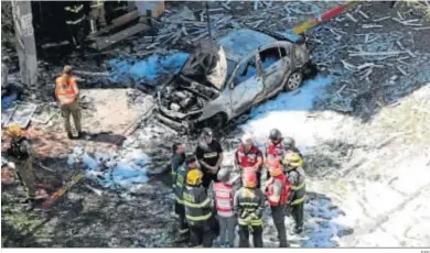  ?? EFE ?? Bomberos y militares inspeccion­an la zona cerca de Tel Aviv donde un cohete de Hamas mató a un hombre israelí.