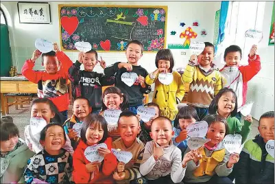  ?? PROVIDED TO CHINA DAILY ?? Students from Fatu Primary School of Qujing, Yunnan province, show their English name cards after taking a VIPkid online English class in September last year.