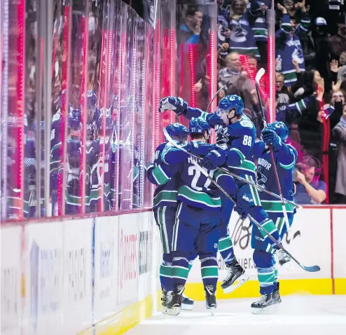  ?? DARRYL DYCK/THE CANADIAN PRESS ?? Vancouver’s Markus Granlund, Ben Hutton, Adam Gaudette and Jake Virtanen celebrate Granlund’s goal against the Avalanche during the third period of Friday’s game at Rogers Arena.