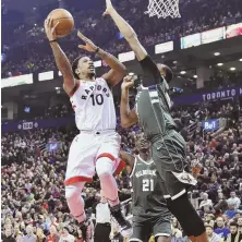  ?? Ap photo ?? GAME OF 52 PICKUP: Raptors guard DeMar DeRozan (left) shoots over a Milwaukee defender on his way to scoring 52 points in a 131-127 overtime win last night.