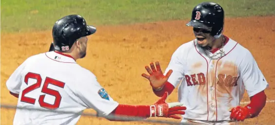  ?? STAFF PHOTO BY STUART CAHILL ?? THAT’S ONE: Mookie Betts is congratula­ted by Steve Pearce after scoring in the first inning of last night’s 8-4 victory against the Dodgers in Game 1 of the World Series at Fenway,