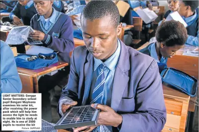  ?? Picture: SUPPLIED ?? LIGHT MATTERS: Gengqe Senior Secondary school pupil Bongani Mayinana examines his solar kit, after receiving the power pack which will help him access the light he needs to enable him to study at night. He is one of 2500 pupils to receive the kit