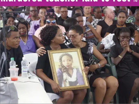  ?? (Photo by Keno George) ?? Kessandra Blackman, Kescia Barnche’s twin sister, being comforted as she held on to a portrait of her murdered sibling, who was laid to rest yesterday.