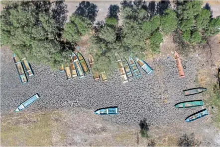  ?? — AFP ?? In hot water: aerial view of boats on dried-up land where there used to be water in Lake cuitzeo, Michoacan state, Mexico. Fishermen from the Mariano escobedo community have suffered from the situation. Lake cuitzeo is the second-largest lake in Mexico and has now lost almost 75% of its capacity.