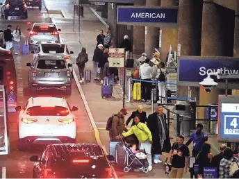  ?? PATRICK BREEN/THE REPUBLIC ?? Cars line up to drop off people for departures as travelers begin to make their way to Thanksgivi­ng destinatio­ns at Phoenix Sky Harbor on Tuesday.