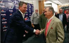  ?? John Bazemore / AP ?? Former Atlanta third baseman Chipper Jones (left) is congratula­ted by former general manager John Schuerholz in Atlanta.