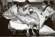  ?? John Minchillo / Associated Press ?? A patient is transferre­d from a nursing home to an emergency room bed at St. Joseph's Hospital in Yonkers, N.Y.