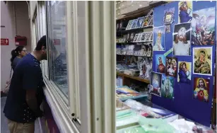  ?? (Hamad Mohammed/Reuters) ?? CATHOLIC WORSHIPERS are seen at a religious store before the Friday evening mass inside the courtyard of the Sacred Heart Catholic Church in Manama, Bahrain, as Catholics await the firstever papal visit to the Persian Gulf.