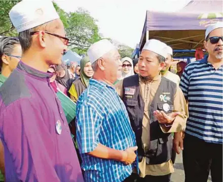  ?? PIC BY MOHD KHIDIR ZAKARIA ?? Pas candidate Lieutenant-Colonel (Rtd) Mohd Nazari Mokhtar (third from left) campaignin­g at Pasar Tani Batu 4 in Port Dickson yesterday.