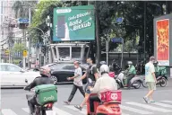  ?? NUTTHAWAT WICHEANBUT ?? Food delivery drivers travelling on Phloenchit Road in Bangkok.