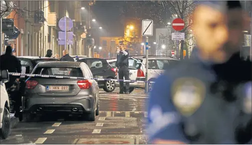  ??  ?? TERROR SWOOP: Police stand guard as a street is sealed off in the Brussels suburb of Schaerbeek. A total of ten people were arrested across Belgium, France and Germany.