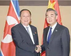  ?? — Reuters ?? Chinese Foreign Minister Wang Yi greets his North Korean counterpar­t Ri Yong Ho, during a bilateral meeting at Manila, on Sunday.