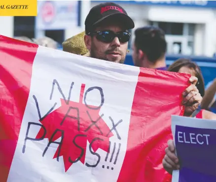  ?? CARLOS OSORIO / REUTERS ?? A man holds an upside-down Canadian flag during a protest at Liberal Leader Justin Trudeau's campaign stop in Brantford, Ont., Monday.