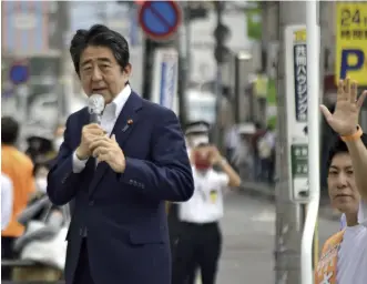  ?? Yomiuri Shimbun file photo ?? Former Prime Minister Shinzo Abe, left, is seen giving a speech in Nara City on July 8, just before he was fatally shot.