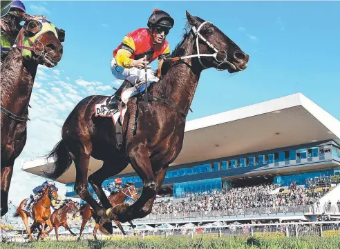  ?? Picture: ALBERT PEREZ ?? SOLID RUN: Jockey Tim Clark rides Dark Dream to victory in race 7, the Channel Seven Queensland Derby, at Doomben.