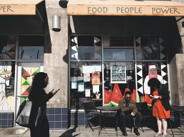  ?? Photos by Michael Short / Special to The Chronicle ?? Oakland’s Mandela Foods Cooperativ­e, above, is one of the new generation of American food co-ops. At left, Mandela Foods worker-owner James Bell bags groceries for customer Bernard Bailey. Far left: A check-out register.