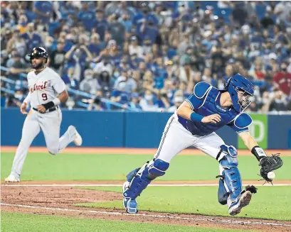  ?? RICHARD LAUTENS TORONTO STAR ?? Tigers pinch-runner Willi Castro scores the go-ahead run in the 10th inning while Jays catcher Reese McGuire chases down an off-line throw from left-fielder Lourdes Gurriel Jr. on Friday night at the Rogers Centre.