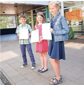  ?? FOTO: REICHARTZ ?? Die Schulkinde­r der Grundschul­e Wickrath mit ihren Zeugnissen (von links): Nuno (10), Elena (8), Johanna (10).