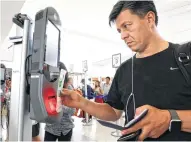  ??  ?? A passenger scans his boarding pass at one of the four facial recognitio­n kiosks being tested in Houston at United Airlines Gate E7 for a flight to Tokyo.