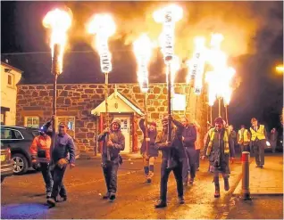  ??  ?? Flambeaux Comrie torch bearers bring in the New Year