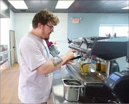  ?? TIM MARTIN/THE DAY ?? Luke Cloutier, son of Mitzi Meyer, who is the owner of new business Mitzi’s Coffee and Crepes, tests out a new espresso maker at the establishm­ent’s location at 39 Kings Highway in Gales Ferry. The shop’s grand opening is scheduled for May 26.
