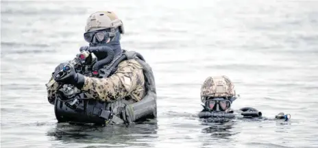  ?? FOTO: CARSTEN REHDER/DPA ?? Kampfschwi­mmer vom Kommando Spezialkrä­fte der Marine gehen bei einer Übung aus der Ostsee an Land.