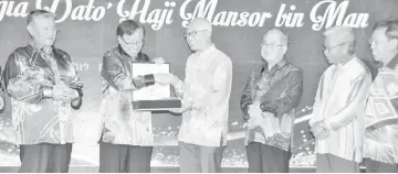  ??  ?? Abang Johari (second left) hands over a memento to Mansor (third left) as (from right) Datuk Dr Sim Kui Hian, Masing, Uggah and Morshidi look on.