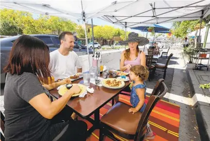  ?? CHARLIE NEUMAN ?? David and Joan Coulter and their daughter, Sabbath, with friend Araceli Gonzalez (at left), enjoy lunch Tuesday in the street dining area of A Delight of France restaurant set up on Grand Avenue in downtown Escondido.