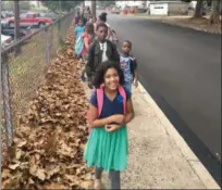  ?? KERRI KLINE — DIGITAL FIRST MEDIA ?? Students line up and walk together as part of Rupert Elementary School’s Walking School Bus makes its way down Center Avenue on its way to school for Internatio­nal Walk to School Day.