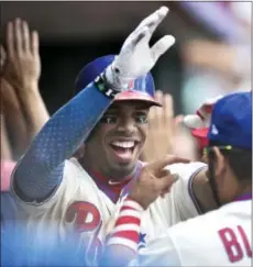  ?? DERIK HAMILTON — THE ASSOCIATED PRESS ?? The Phillies’ Nick Williams, left, high fives Andres Blanco in the dugout after Williams hit a two-run home run off the Brewers’ Junior Guerra during the fourth inning Sunday in Philadelph­ia.