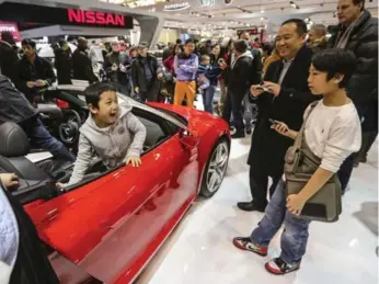  ??  ?? Justin Lee, 7, smiles back at his dad, Rob, and brother Jordan, 10, as he climbs out of the Audi R8 Spyder at the 2015 show. There’s plenty of things for kids to do and a daycare centre for younger kids.