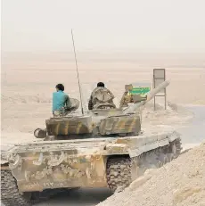  ?? SANA VIA AP ?? Syrian soldiers sit on top of a tank during fighting between government forces and Islamic State group militants in Palmyra, Syria, on Sunday. Russian airstrikes have helped drive Islamic State fighters from the historic town, held by the extremists...