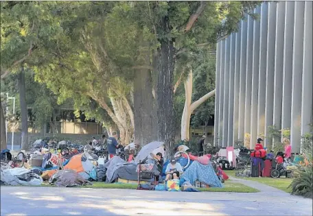  ?? Photograph­s by Allen J. Schaben Los Angeles Times ?? HOMELESS gather outside the Santa Ana Civic Center in 2016. City officials have blamed a needle exchange for syringes discarded there.