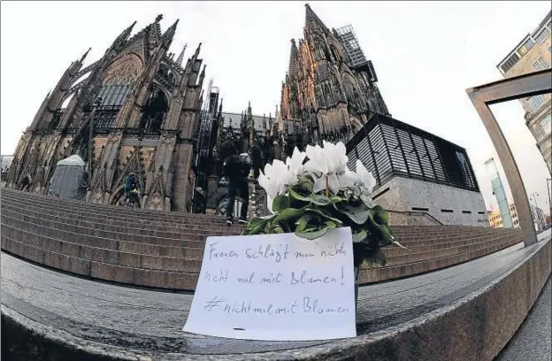  ?? ROBERTO PFEIL / AFP ?? A l’escalinata de la catedral de Colònia, molt a prop del lloc de les agressions, un paper diu: “A les dones no se’ls pega, ni tan sols amb flors”