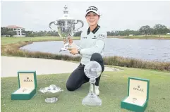  ?? AFP ?? Lydia Ko poses with the Tour Championsh­ip, Player of the Year and Vare trophies.