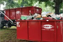  ?? Doug Walker ?? Retired Floyd County police officer Jim Treglown drops off another container in June 2019 as county police, 911 personnel and others helped to clean out the home of a retired county employee who is disabled. This year’s project will benefit an elderly cancer patient who has been living without garbage pickup or without air conditioni­ng for quite some time.