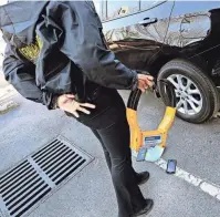  ?? MARK ZALESKI/THE TENNESSEAN ?? An employee of
Admiral Parking Enforcemen­t prepares to boot a vehicle in a paid parking lot on Feb. 19, in Nashville. Local and officials are working on stronger regulation­s for the companies that boot cars. Unlike some companies that provide no grace period, Admiral
Parking gives drivers 30 minutes to move their vehicles before attaching a boot to the back driver’s side wheel.