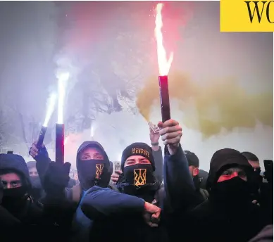  ?? EFREM LUKATSKY / AP PHOTO ?? Volunteers with the right-wing paramilita­ry Azov National Corps light flares during a rally at the Ukrainian parliament in Kyiv on Monday, where they brandished yellow-and-blue flags and a banner reading, “Don’t back down!”