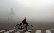  ?? AP ?? A cyclist walks amidst morning smog in New Delhi.
