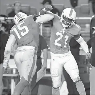  ?? JOHN MCCALL/SOUTH FLORIDA SUN SENTINEL ?? Dolphins linebacker Jaelan Phillips, left, and safety Eric Rowe celebrate after stopping the Ravens on third down during the second half at Hard Rock Stadium on Thursday.