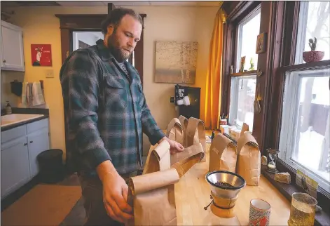  ??  ?? Johnson sorts through the bags of his previously roasted batches of beans Along with his wife, Becky, the pair are sharing their creations with other coffee lovers at Thinkwell, an online ordering system where customers can purchase customized coffee beans.