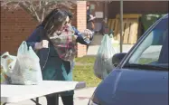  ?? H John Voorhees III / Hearst Connecticu­t Media ?? Volunteer Bianca Perrone, of Bethel, helps distribute lunch and breakfast bags at Berry School on Wednesday morning in Bethel.