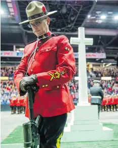  ??  ?? An RCMP officer is a sentry during the Remembranc­e Day service at Brandt Centre. Hundreds gathered Saturday to honour those who served.