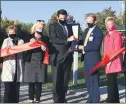  ?? PHOTO SUBMITTED ?? Sterling Heights Mayor Michael Taylor, center, cuts the red ribbon marking the start of a a trail expansion that will connect the city’s park to the hospital.