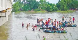  ??  ?? La desesperac­ión llevó a muchos hondureños a saltar desde el puente que atraviesa el río Suchiate, para cruzar nadando, o pagar para ser trasladado­s por los balseros.